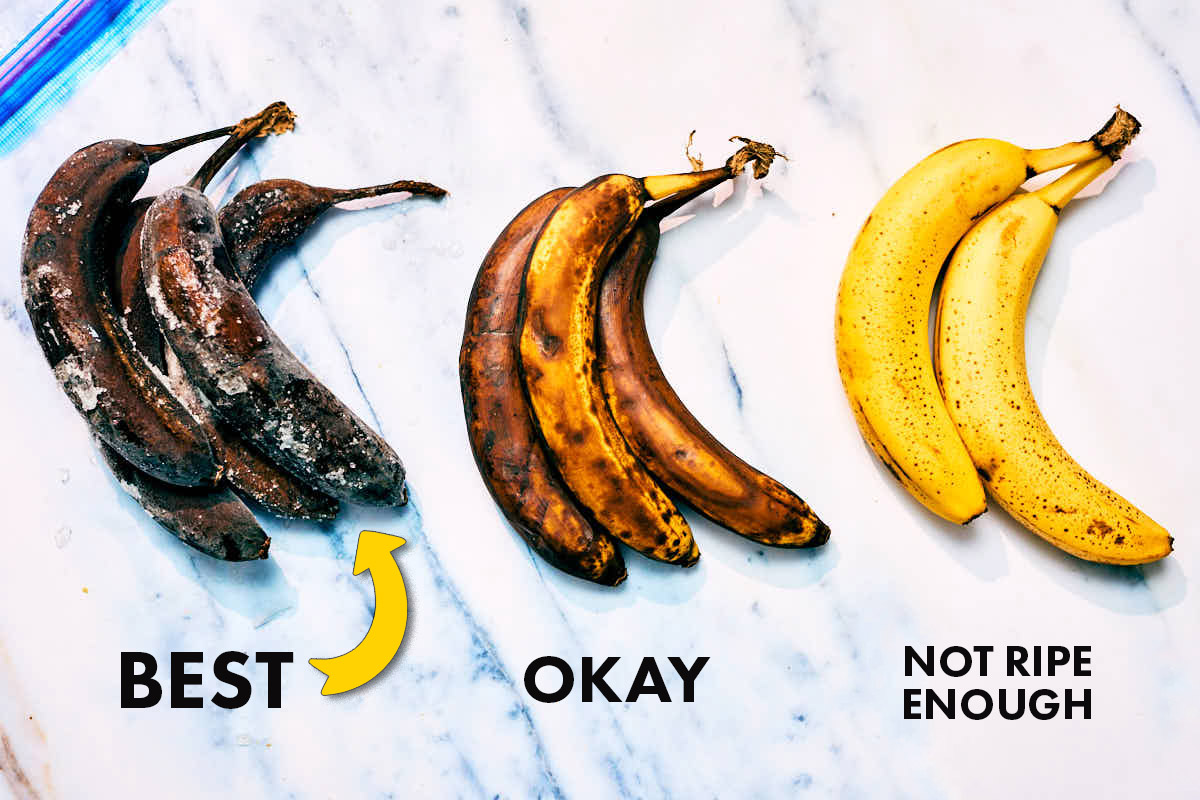 Bananas of varying ripeness on a marble counter.