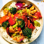 A bowl of Kung Pao Vegetables with Tofu and rice.