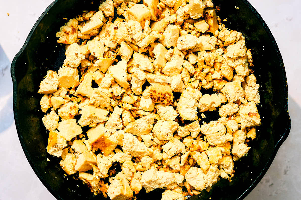 Crumbled tofu sauteed until golden brown in a skillet.