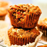 Two vegan Banana Carrot Muffins stacked on top of each other.