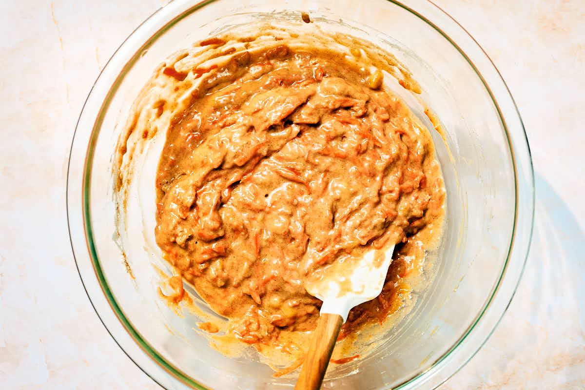 Vegan carrot banana muffin batter in a glass bowl.