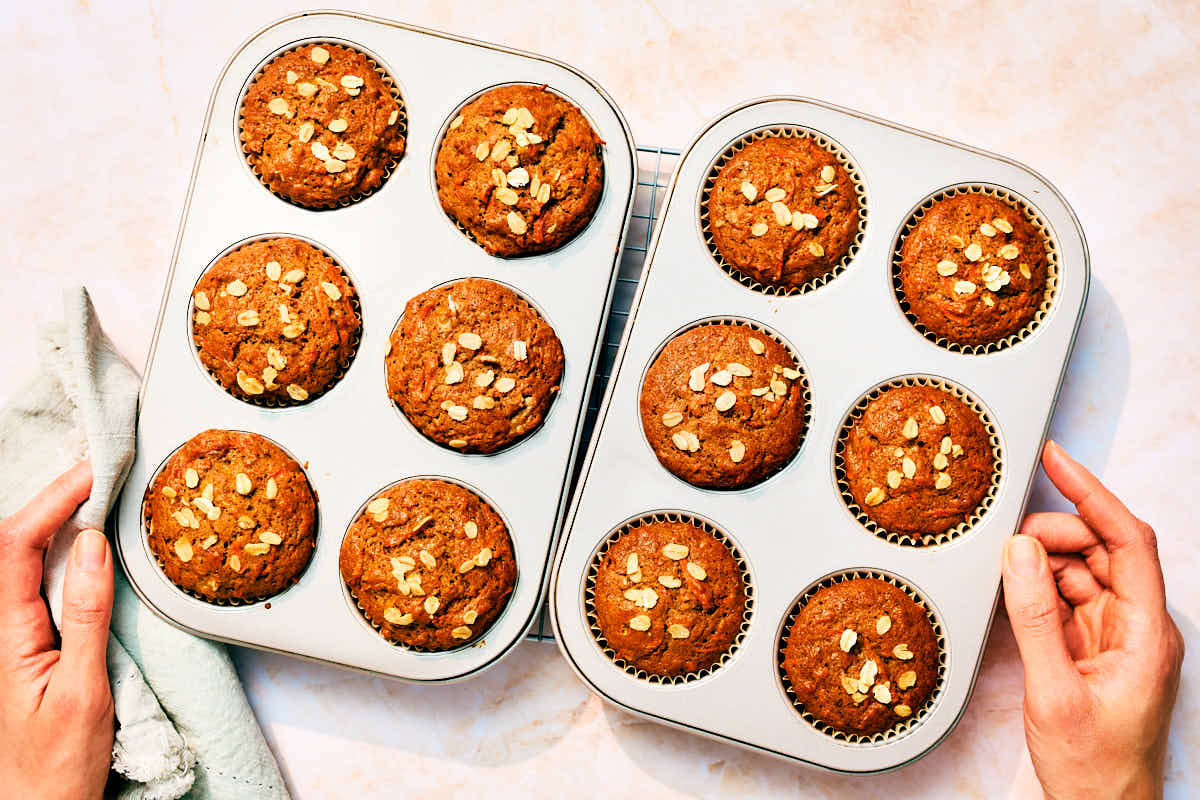 Moist banana carrot muffins in muffin tins after baking.