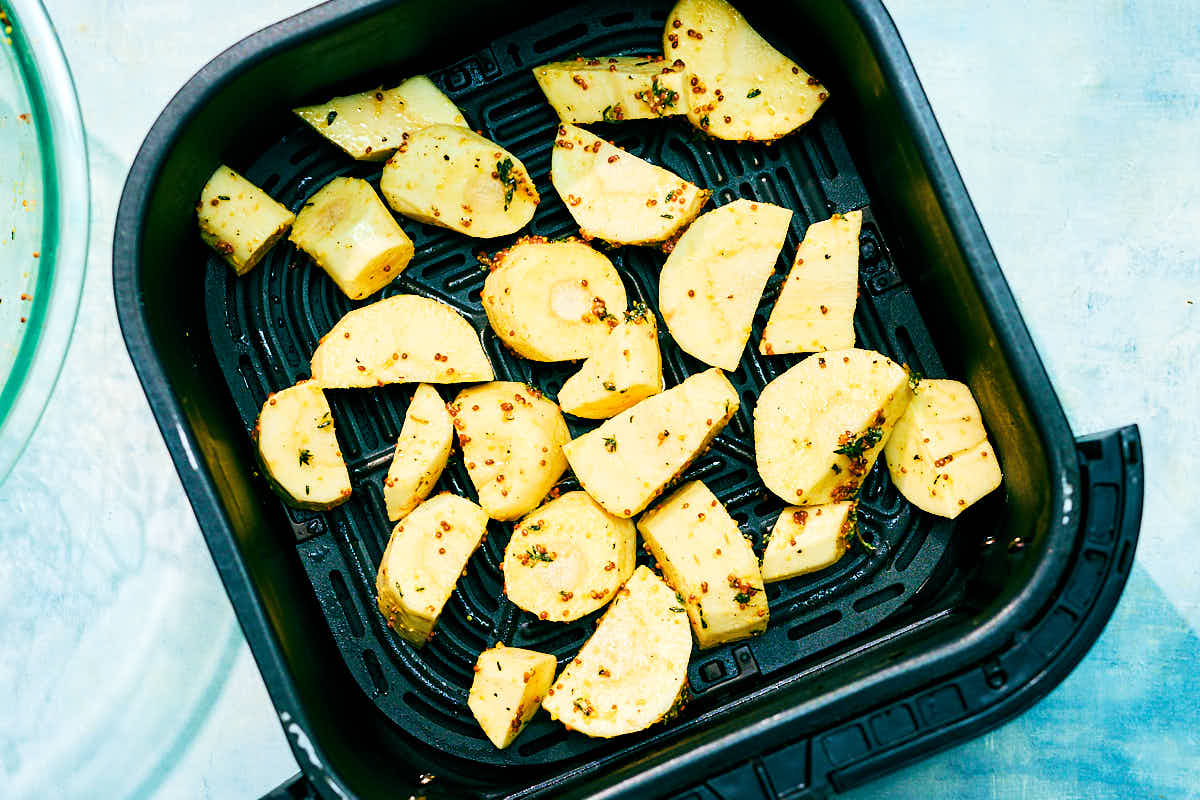 Air Fryer Parsnips in an air fryer basket before baking.