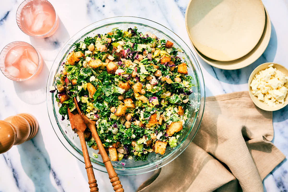 Chopped Dill Pickle Salad with feta in a serving bowl on a marble counter.