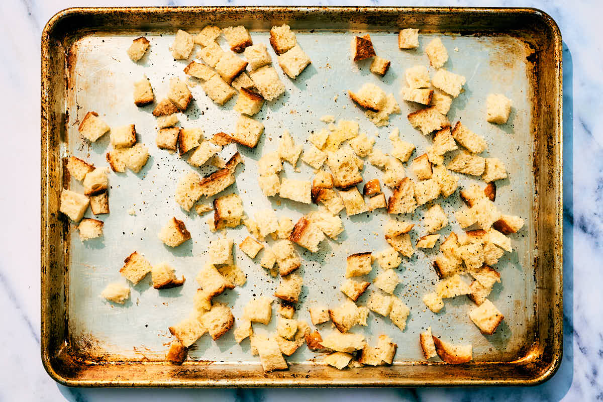 Cubed bread on sheet tray before getting baked into croutons.