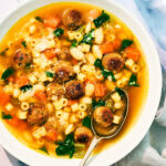 Vegan Italian Wedding Soup in a bowl with a spoon.
