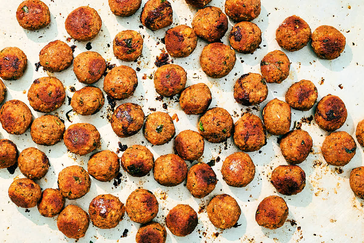 Crispy vegan meatballs on a sheet pan after baking.