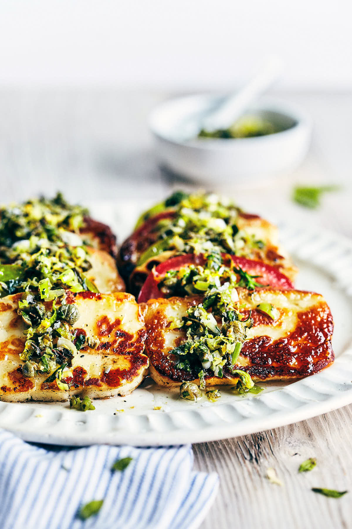 Seared Halloumi with Tomatoes and a fresh herb topping on a plate.