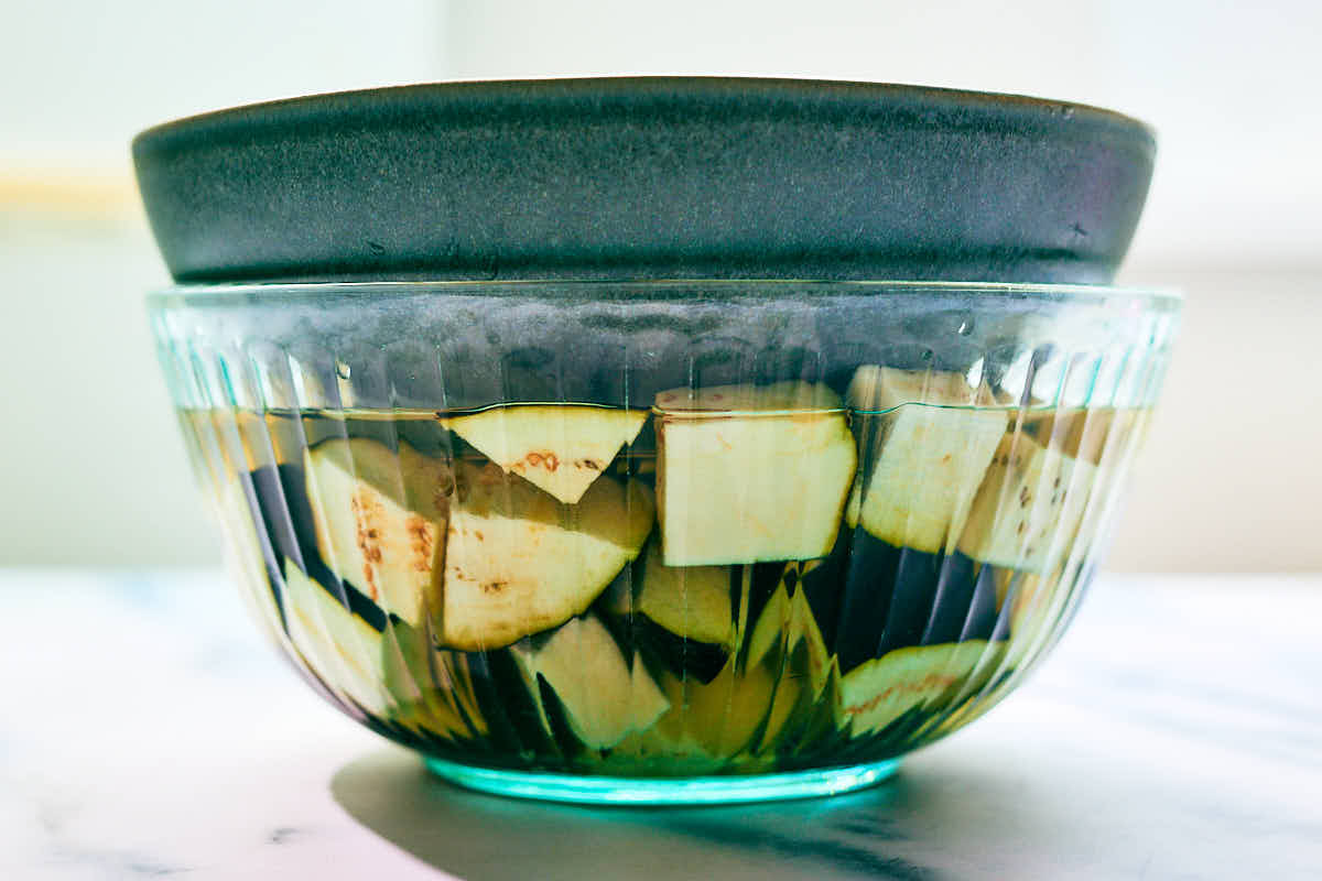 Chopped eggplant soaking in salt water before cooking.