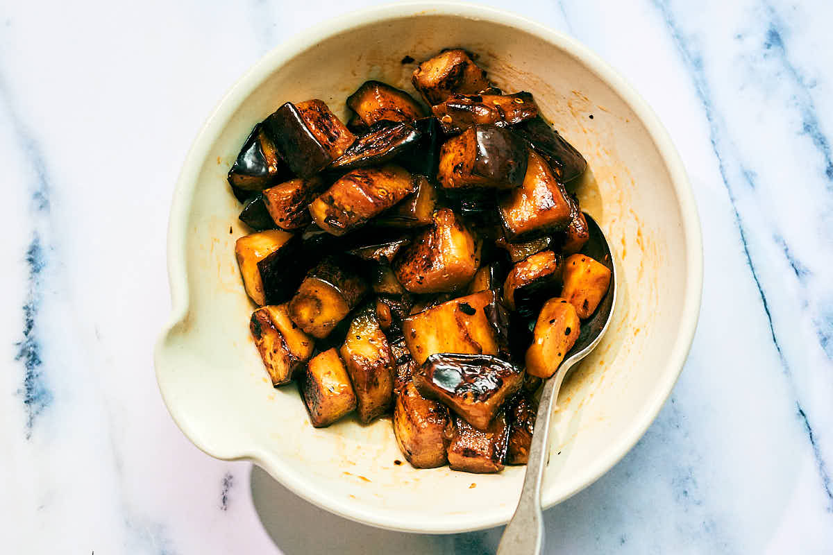 Seared eggplant seasoned with tamari and sesame oil in a bowl.