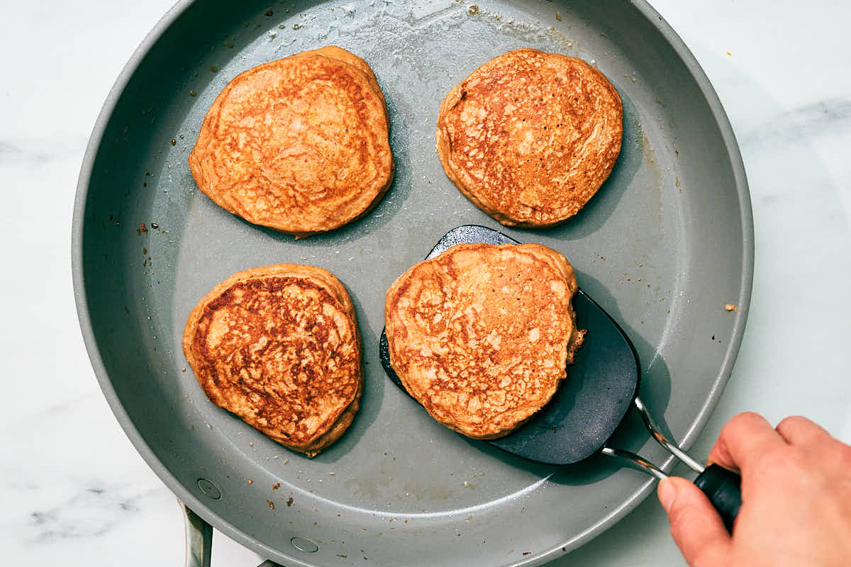 High protein cottage cheese pancakes being cooked in a skillet.