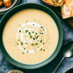 Slow Cooker Potato Leek soup topped with cream and chives in a bowl.