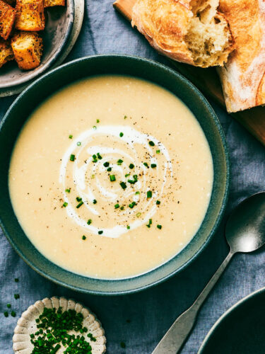 Slow Cooker Potato Leek soup topped with cream and chives in a bowl.