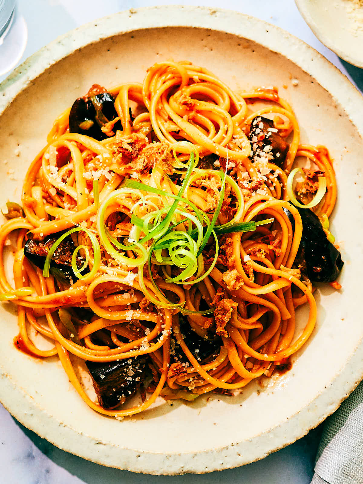 Easy Gochujang Pasta with Eggplant and Scallions on a dinner plate.