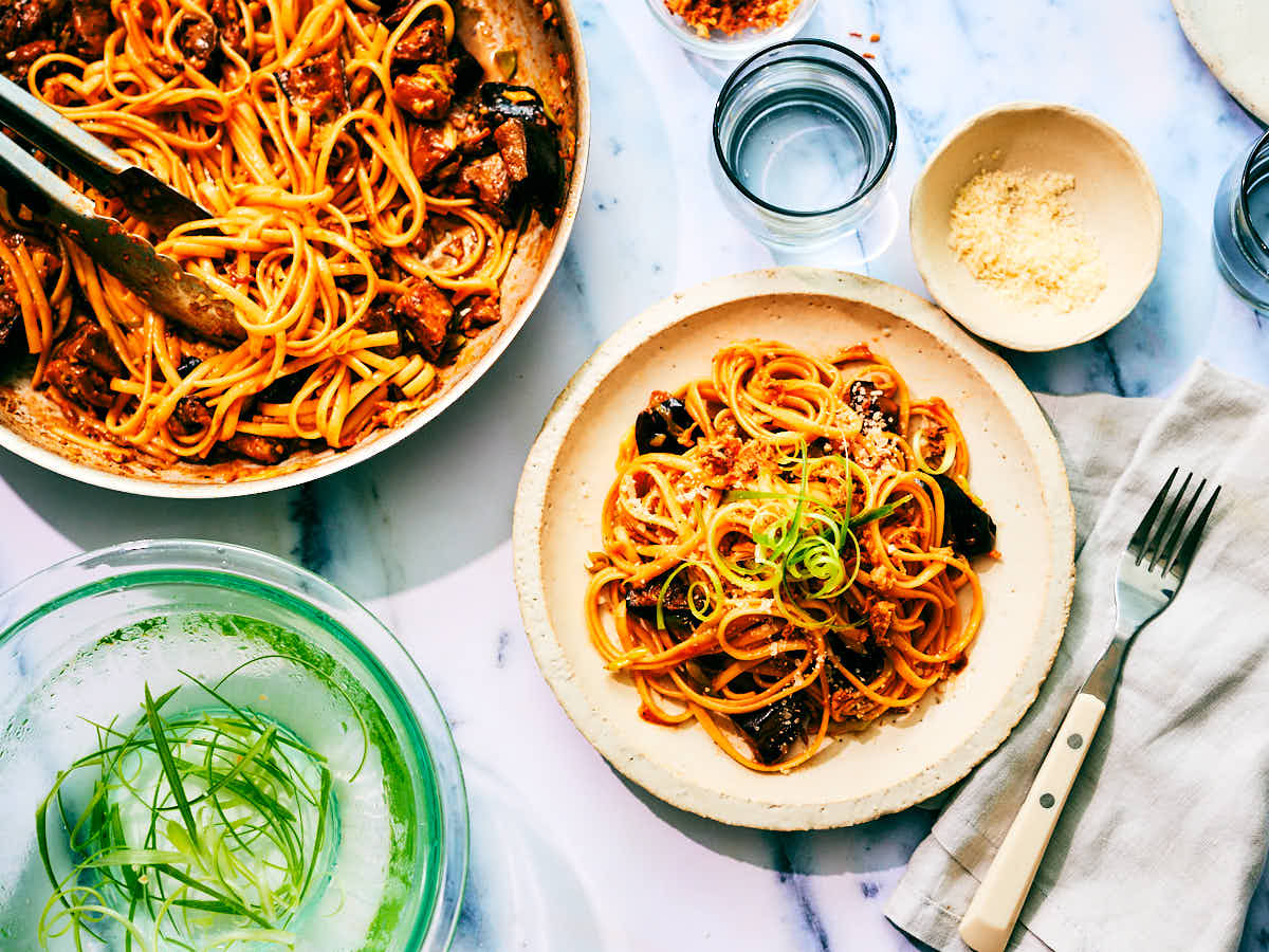 Silky Gochujang Pasta with Eggplant in a skillet and on a dinner plate.
