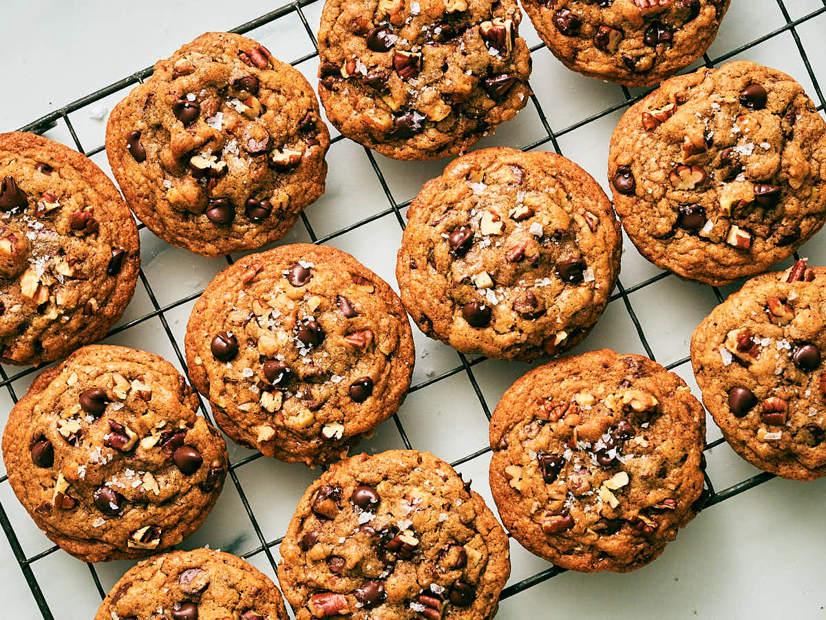 Chocolate Chip and Pecan Cookies topped with flaky salt on a cooling rack.