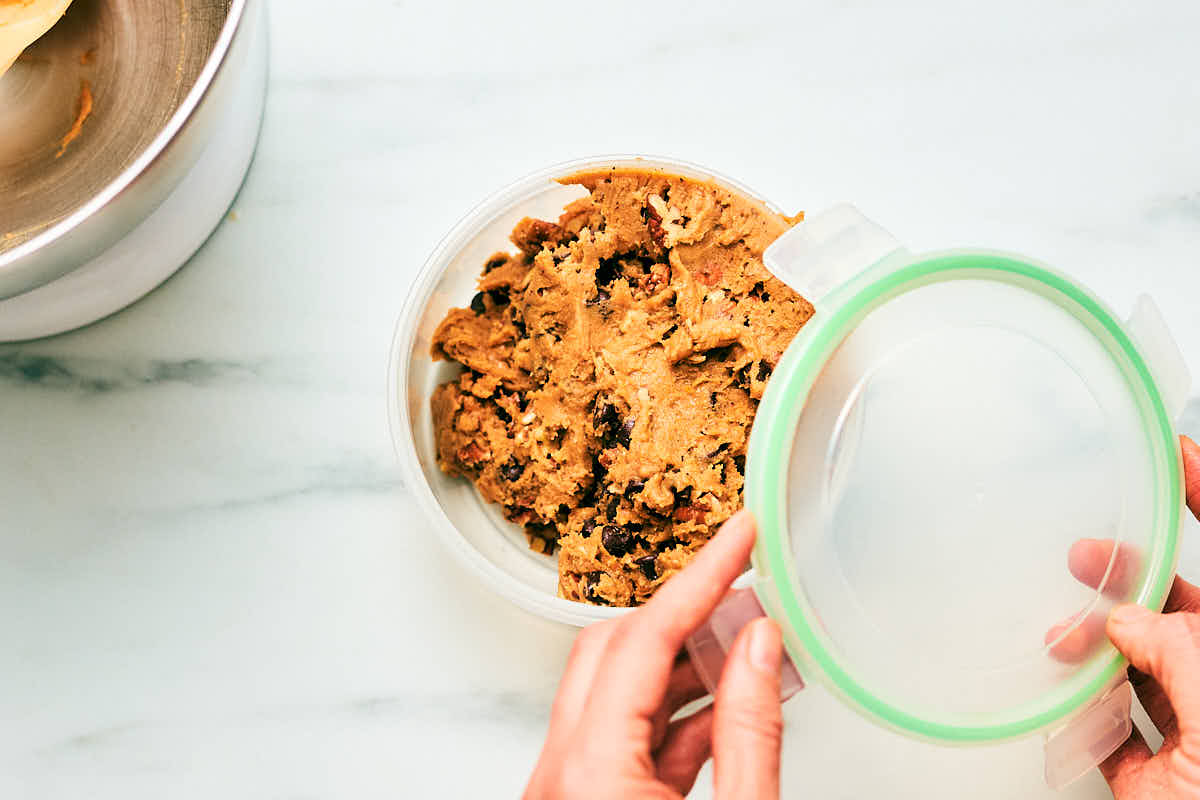 Evergreen Kitchen cookie dough being put in a container to refrigerate.