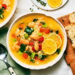 A bowl of Lemony Rice and White Bean Soup with vegetables.