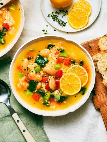 A bowl of Lemony Rice and White Bean Soup with vegetables.