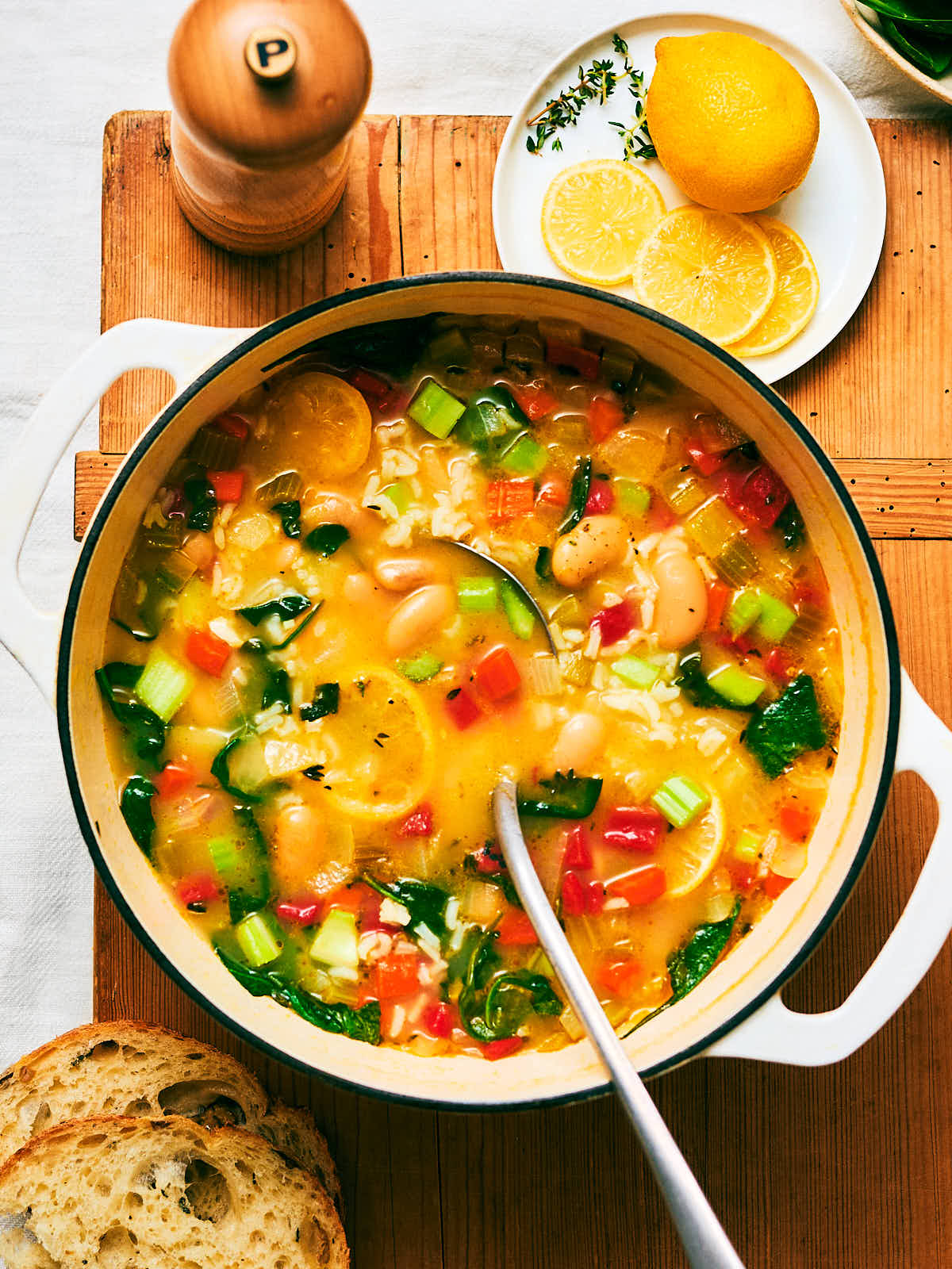 Vegan Lemony Rice and White Bean Soup in a pot with a ladle for serving.