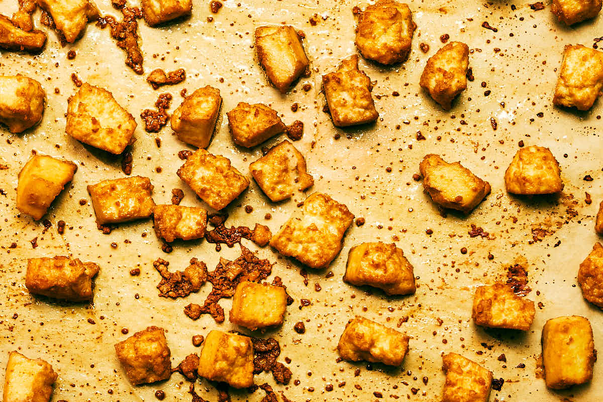 Crispy, golden brown tofu on a baking sheet after baking.
