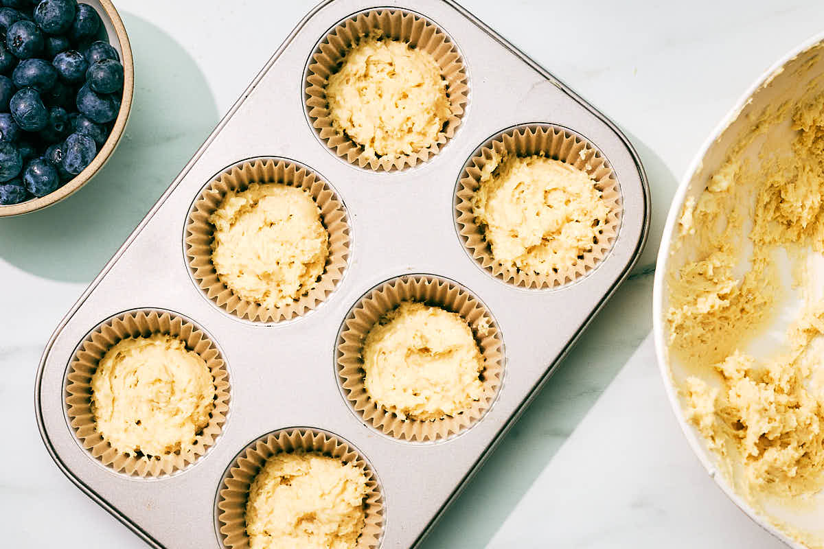 Cottage cheese muffin batter scooped into a muffin tin.