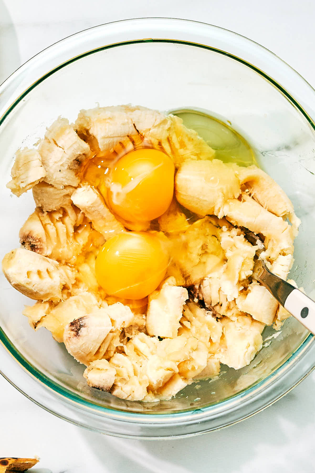 Eggs and banana in a bowl to ripen the bananas before making banana bread muffins.