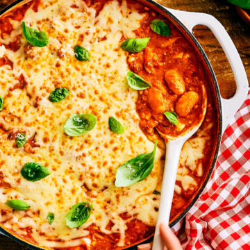 Evergreen Kitchen's vegetarian high protein Pizza Beans in a skillet, topped with basil.