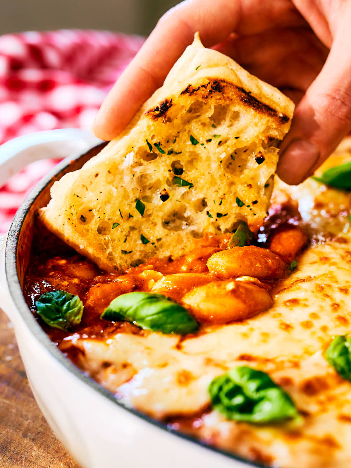 Garlic bread being dipped into high protein pizza beans made with cottage cheese.