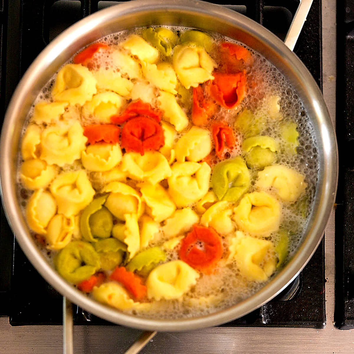 Cheese tortellini boiling in a pot of water on the stove.