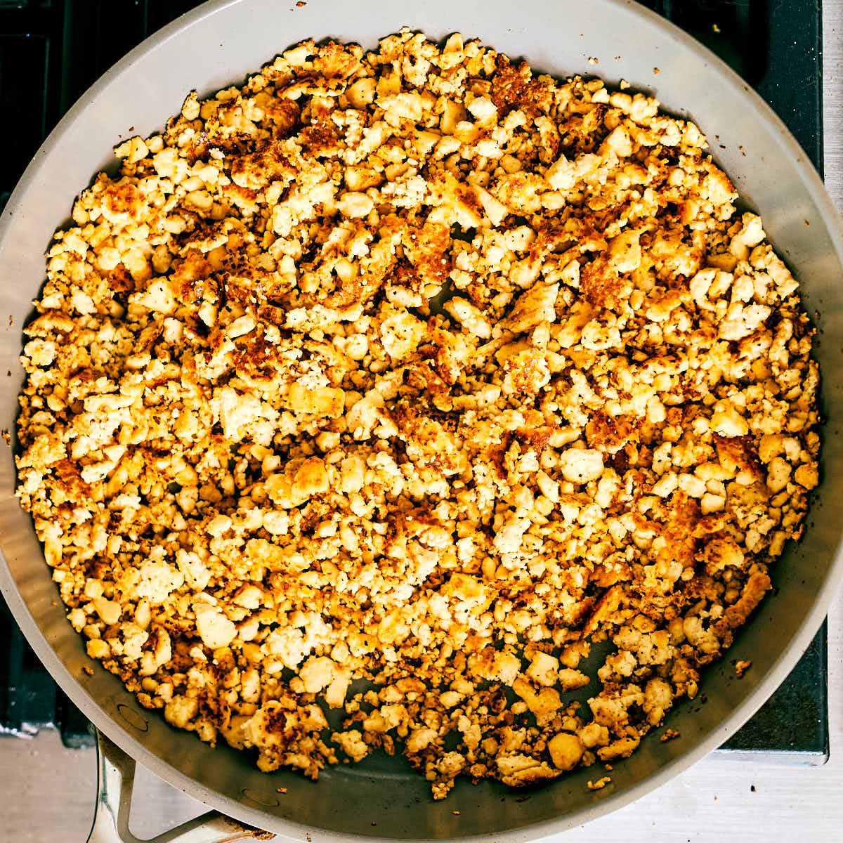 Crumbled tofu sautéed in a skillet until golden brown.