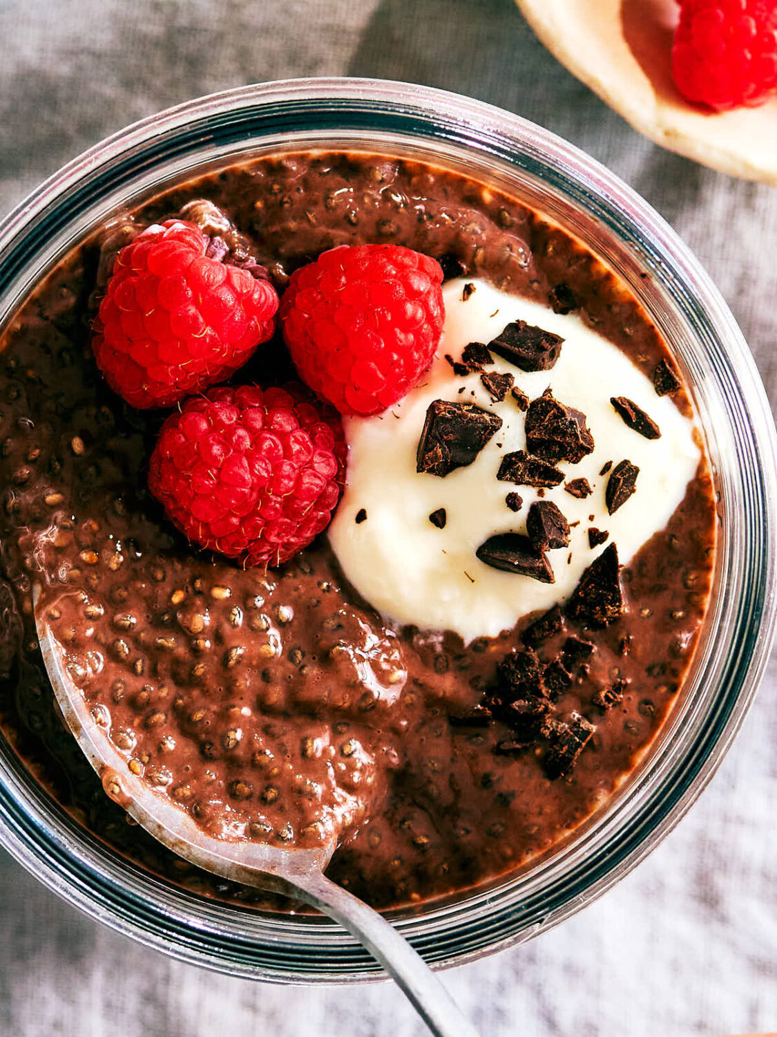 Evergreen Kitchen's Chocolate Chia Pudding topped with yogurt and raspberries.