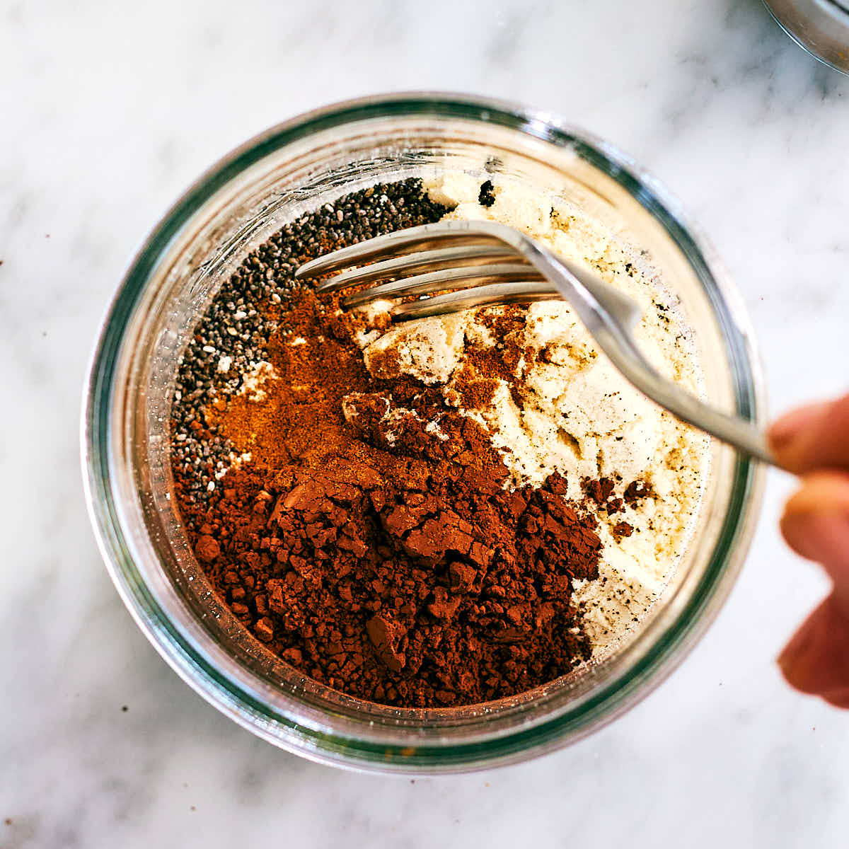 Ingredients for Chocolate Chia Pudding with protein powder in a jar.
