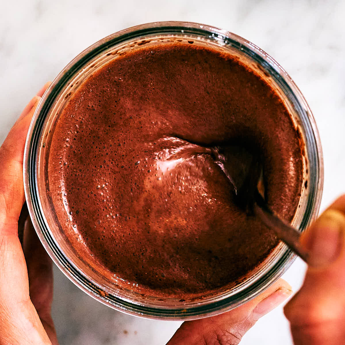 A fork mixing High Protein Chocolate Chia Pudding in a jar.
