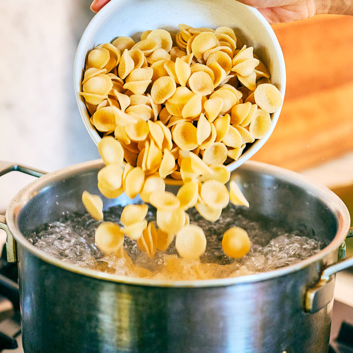 Pasta being added to a pot of boiling water.